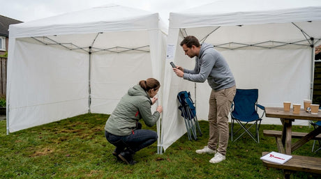 Twee mensen bekijken samen verschillende partytenten in de tuin om te zien welke het beste past.