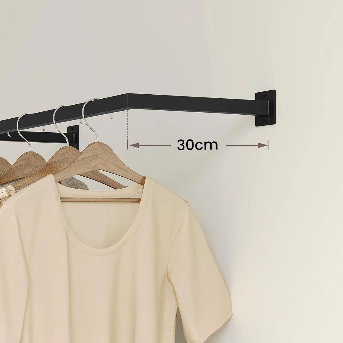 Zwarte kledingroede aan de muur met kledinghangers en aanduiding van 30 cm wandafstand