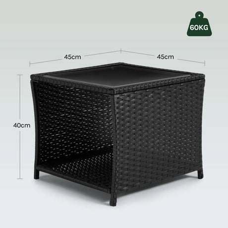 Luxe polyrattan bijzettafel van BukkitBow met glazen blad en opbergvak, geschikt voor buitengebruik.