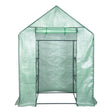 Groene foliekas met opgerolde deur onder het puntdak en zichtbaar frame in de opening